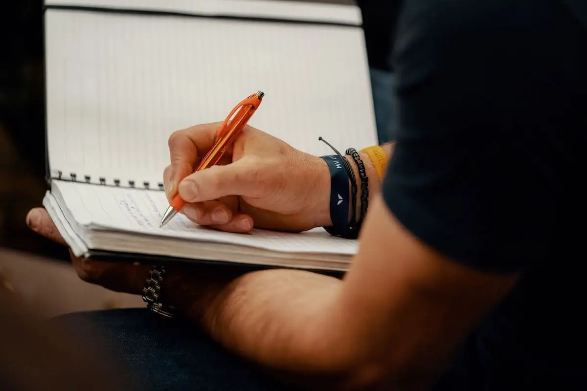 Person writing in a notebook their vision vs. mission statement