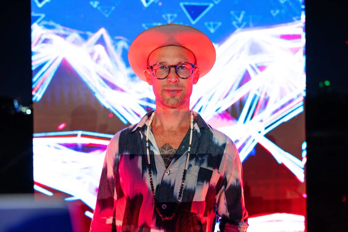 Man posing in front of a Mindvalley art wall