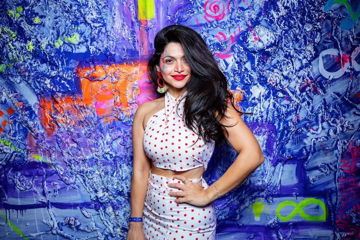 Woman posing in front of a colorful wall