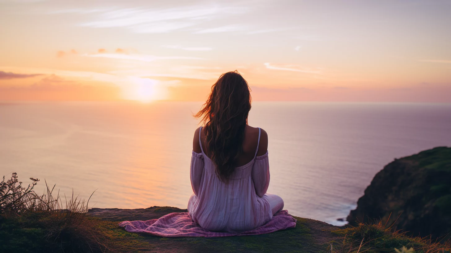 A woman sitting at the edge of a cliff thinking of how to get over someone