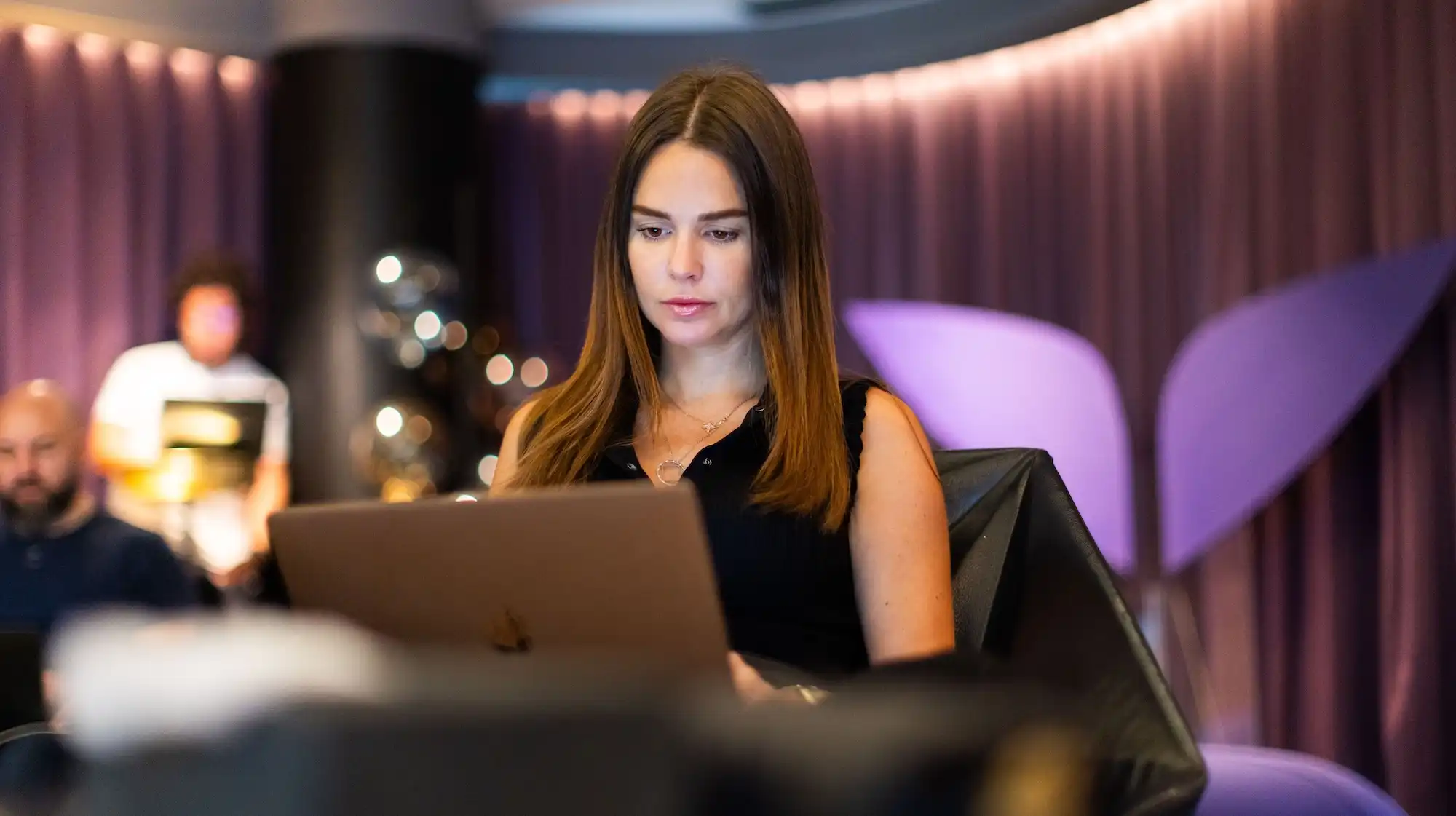 A woman working on a laptop at a Mindvalley event