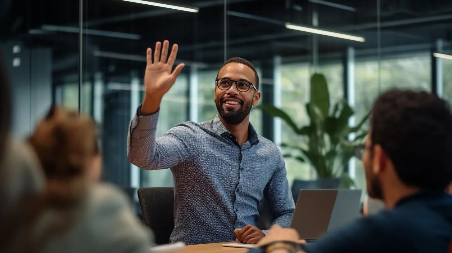 A man wearing spectacles and a blue shirt waves his hand in a workplace setting