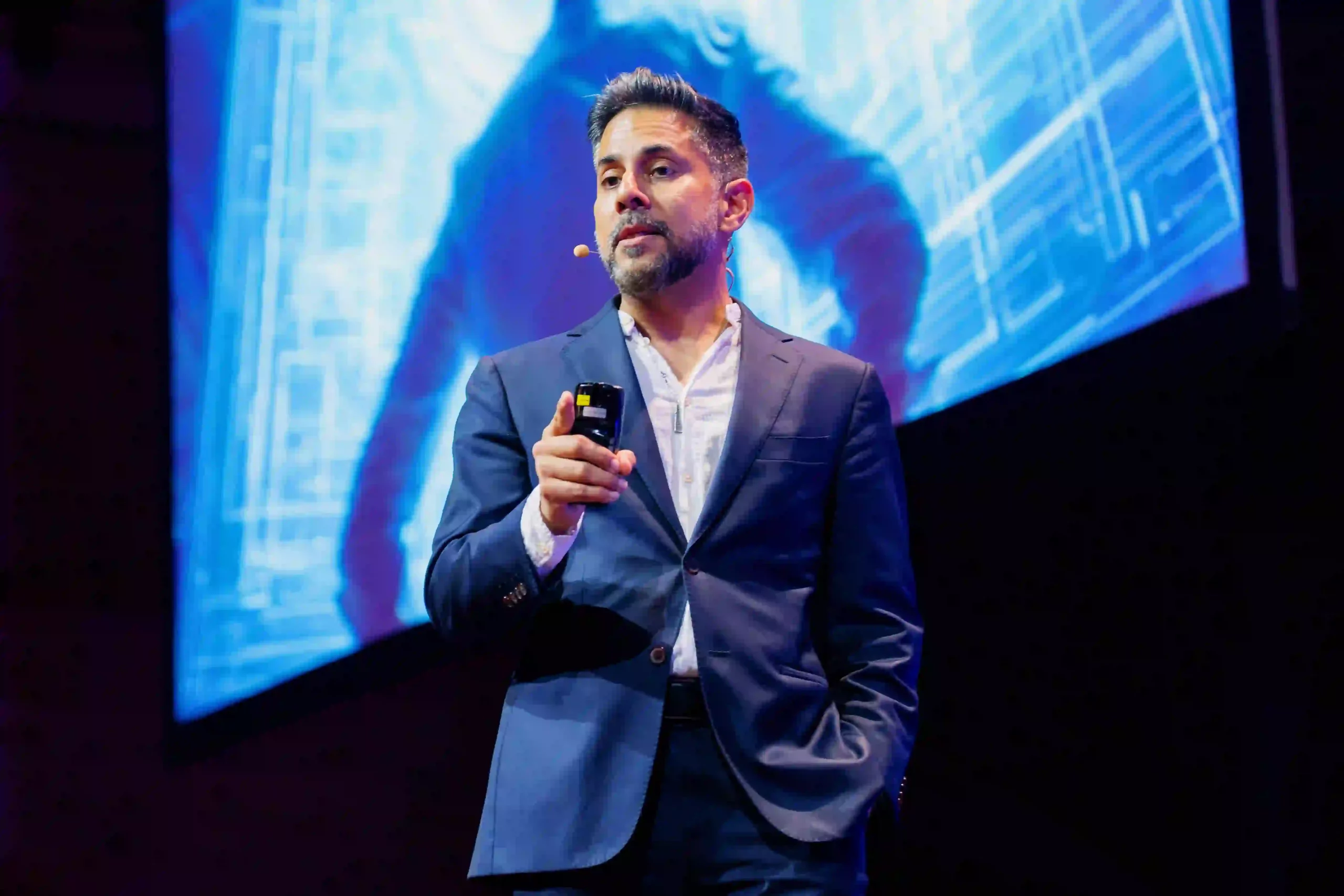 Vishen Lakhiani speaking at a Mindvalley stage to and audience of entrepreneurs