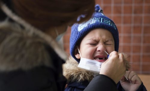 Mujer realiza prueba covid a niño