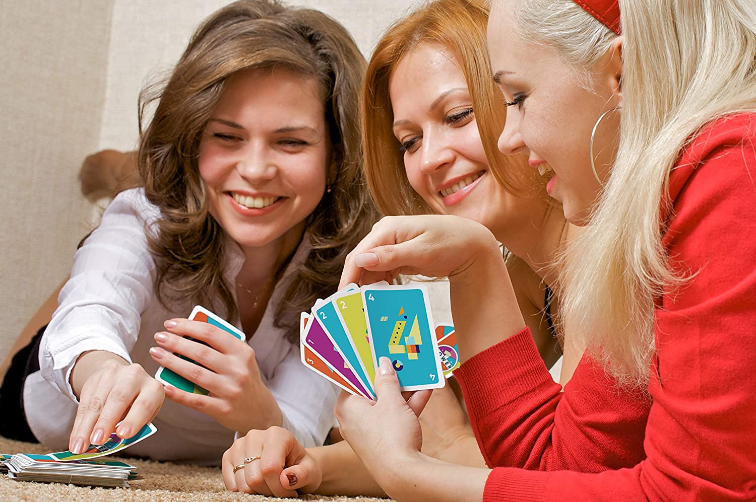 Three women lying on floor playing Power1