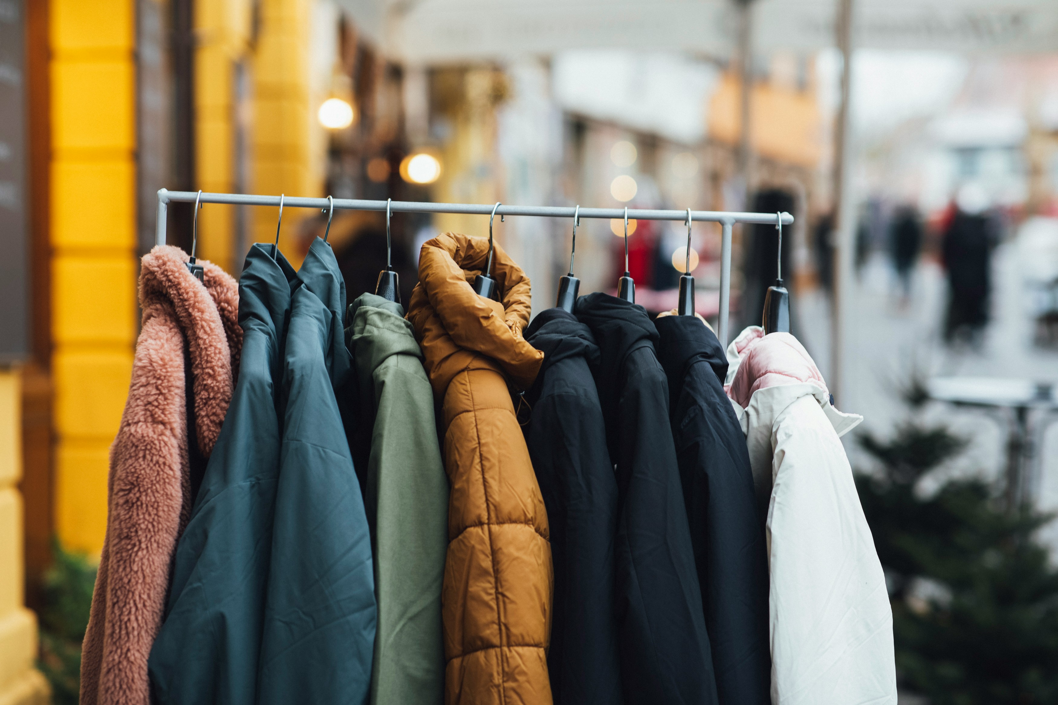 A collection of warm winter coats hanging on a rack, ready for donation.