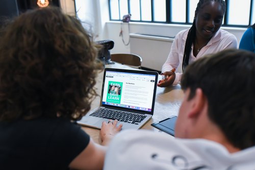 Girl looking at laptop with "Earn, Save, Learn" tagline.