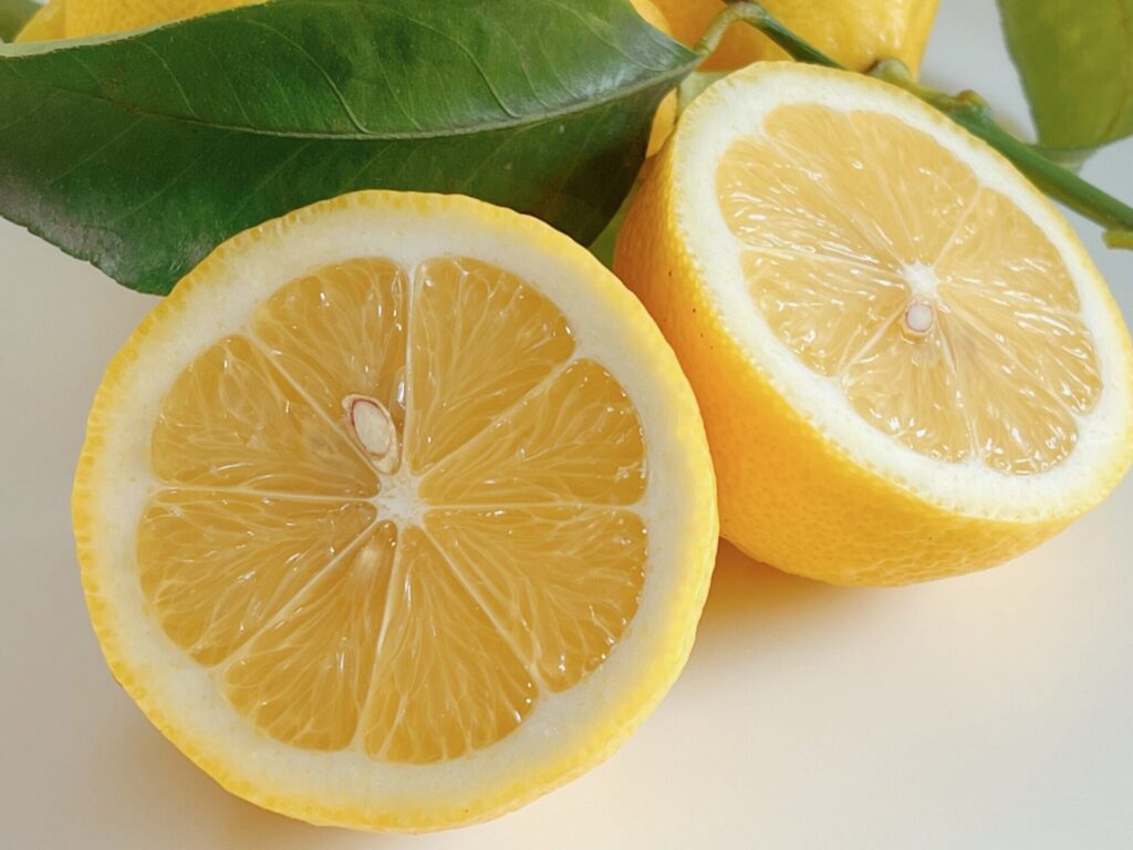 瀬戸内産レモンを半分に切って白いテーブルに並べた写真