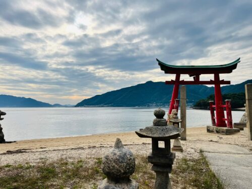 鳥居側から撮影した鳥居と海、空の写真