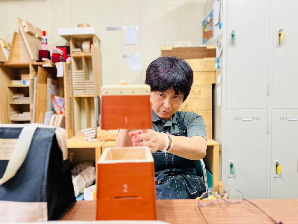 豊田裕子さんが『トビコバコ』を積み上げる写真