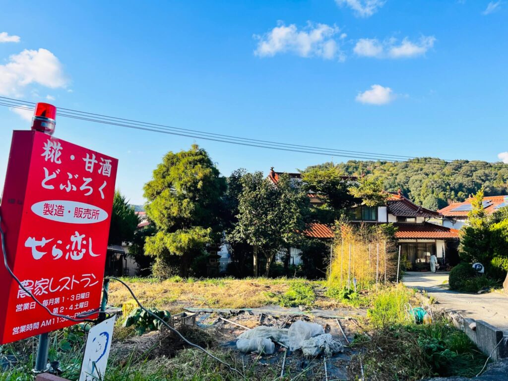 『どぶろく せら恋し』の看板と遠くから見たお店の風景