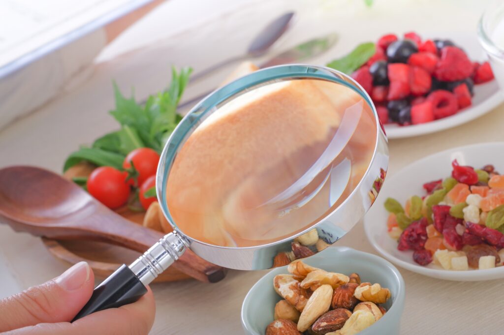 ドライフルーツやナッツなどの食品を虫眼鏡で見ている写真