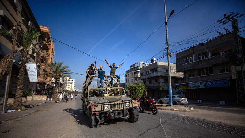 Palesztin férfiak egy izraeli katonai járművön 