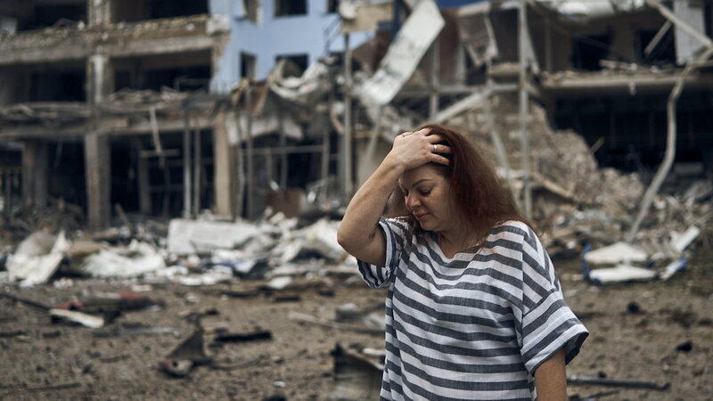 Megrongált lakóház előtt egy nő Mikolajivban 2022. augusztus 3-án, miután orosz rakétatámadás érte a dél-ukrajnai várost.