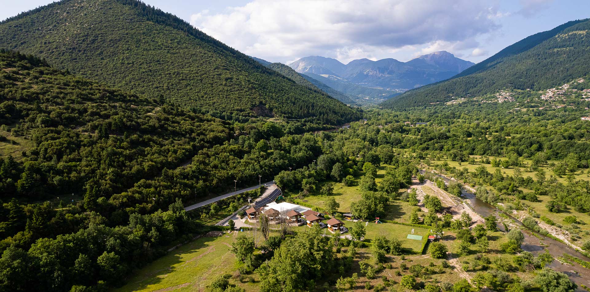 Aerial view of a valley with mountains in the background.