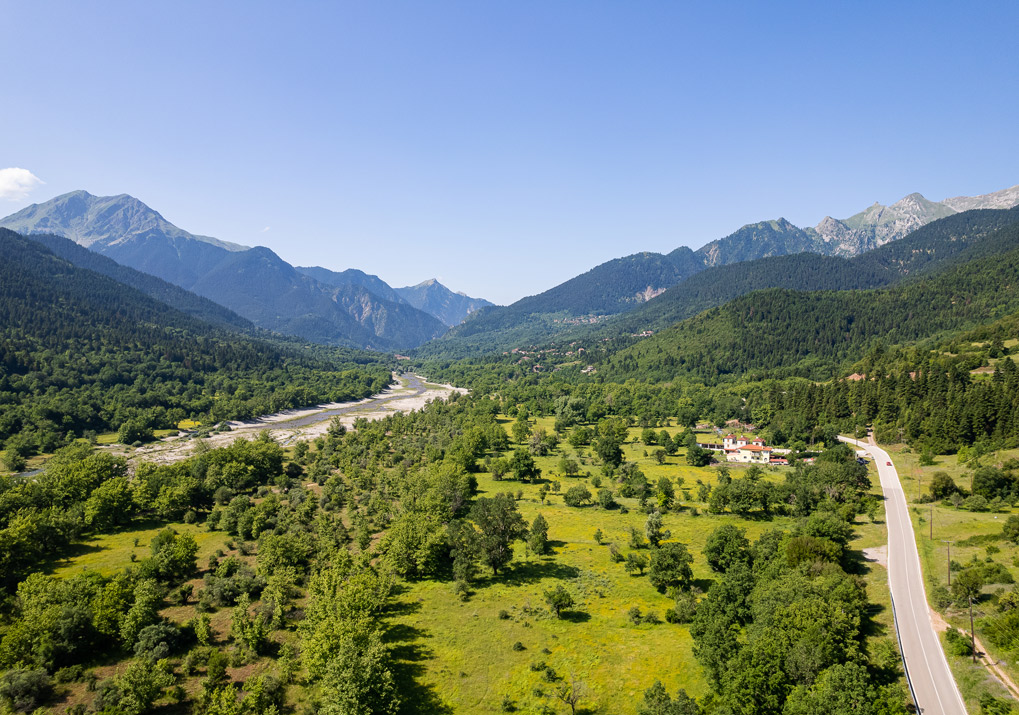 Aerial view of a valley with mountains in the background.