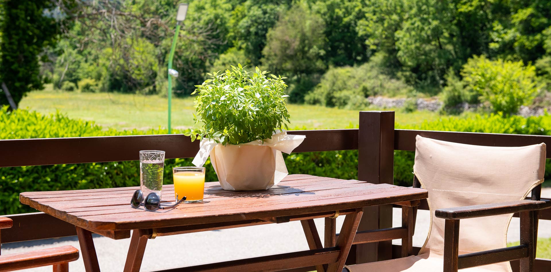 Ξύλινο τραπέζι με χυμό πορτοκάλι στο μπαλκόνι του Natura Chalet Lux