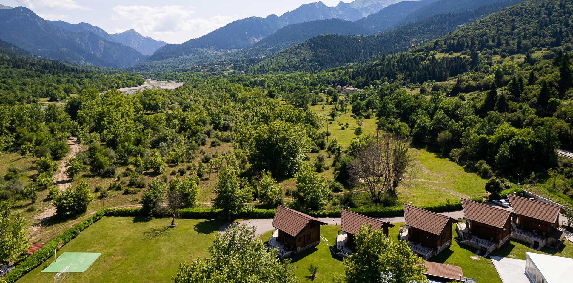 Aerial view of Natura Chalets with mountains in the background