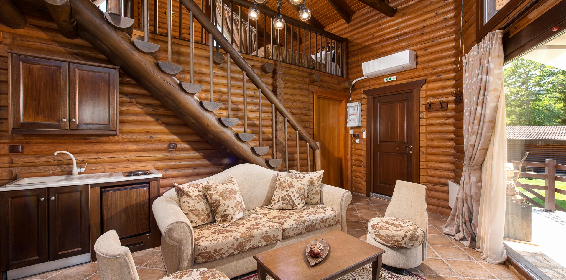 Natura Chalet living room with wooden staircase at the back