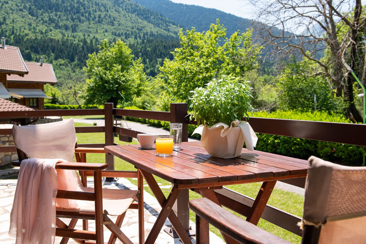 Wooden table with orange juice and mountains in the background