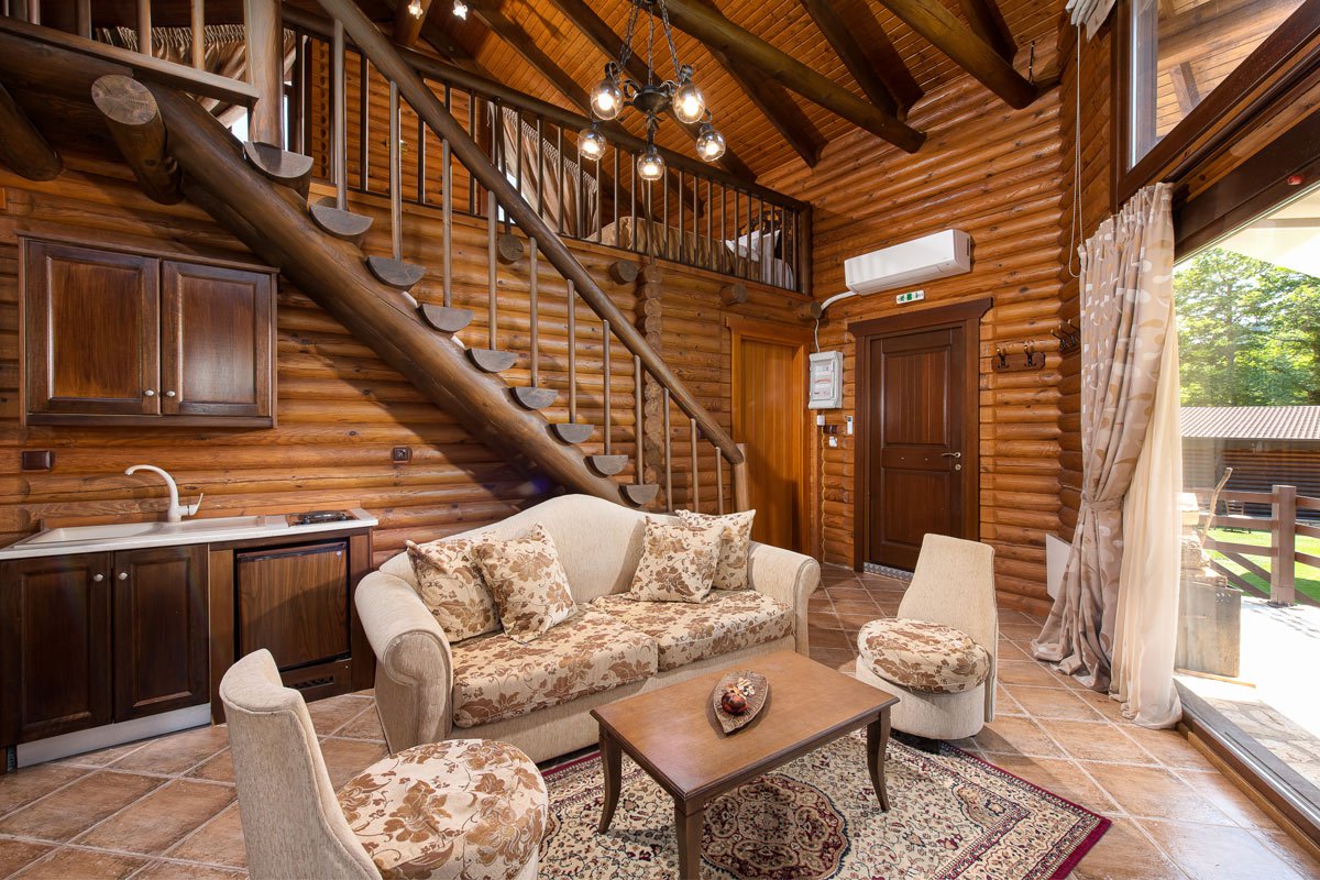 Natura Chalet living room with wooden staircase at the back