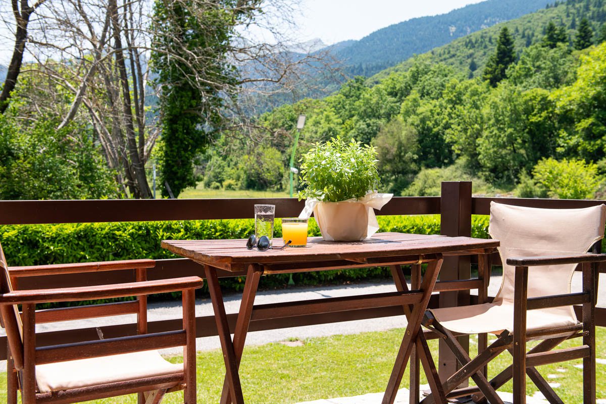 Wooden table with orange juice and mountains in the background