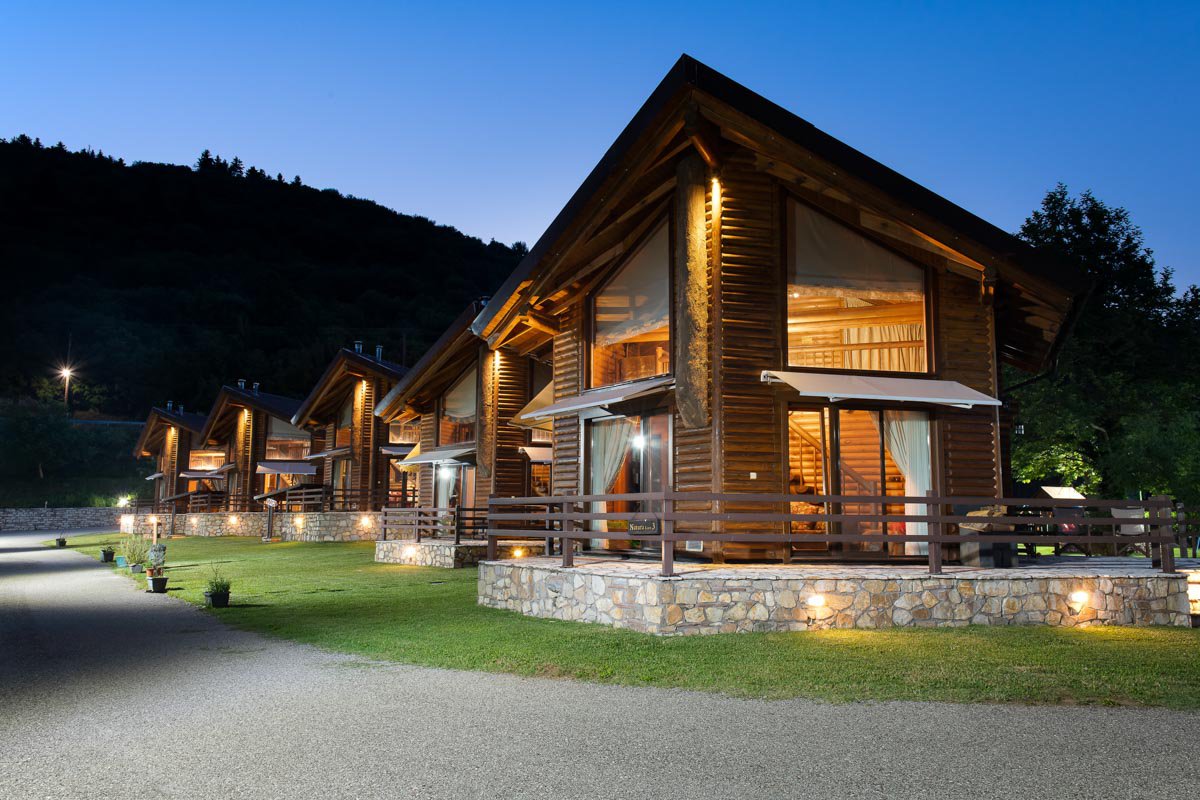 The Natura Chalets, one behind the other, with the night lights turned on