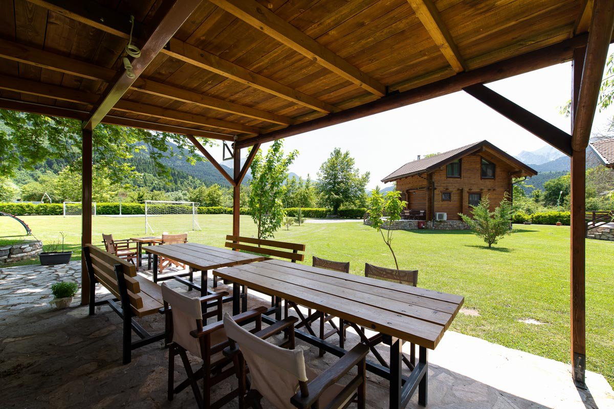 A covered patio with a table and chairs