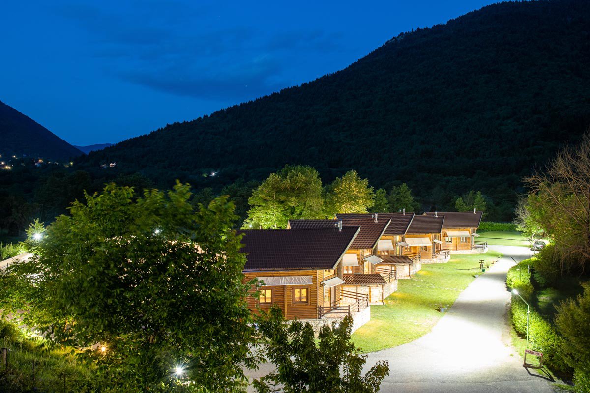 The Natura Chalets, one behind the other, with the mountains in the background at night