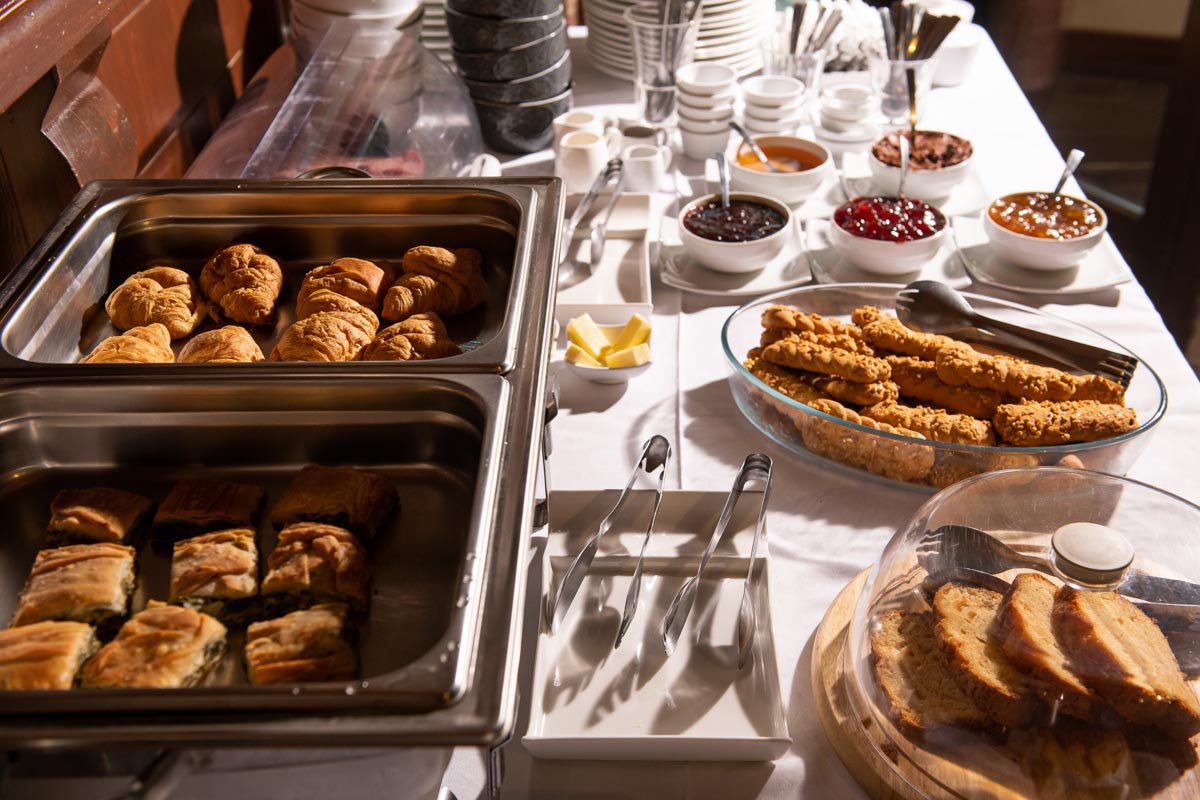 A buffet table with pastries and breads