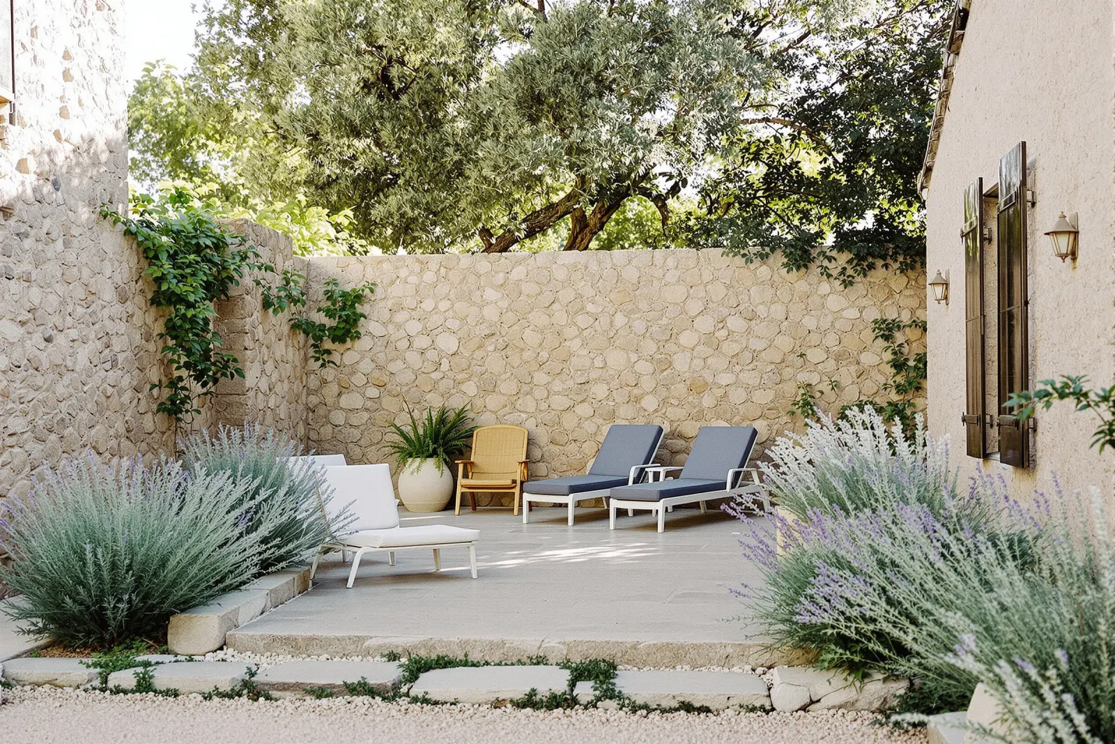 Walled garden with sun loungers between lavender and rosemary