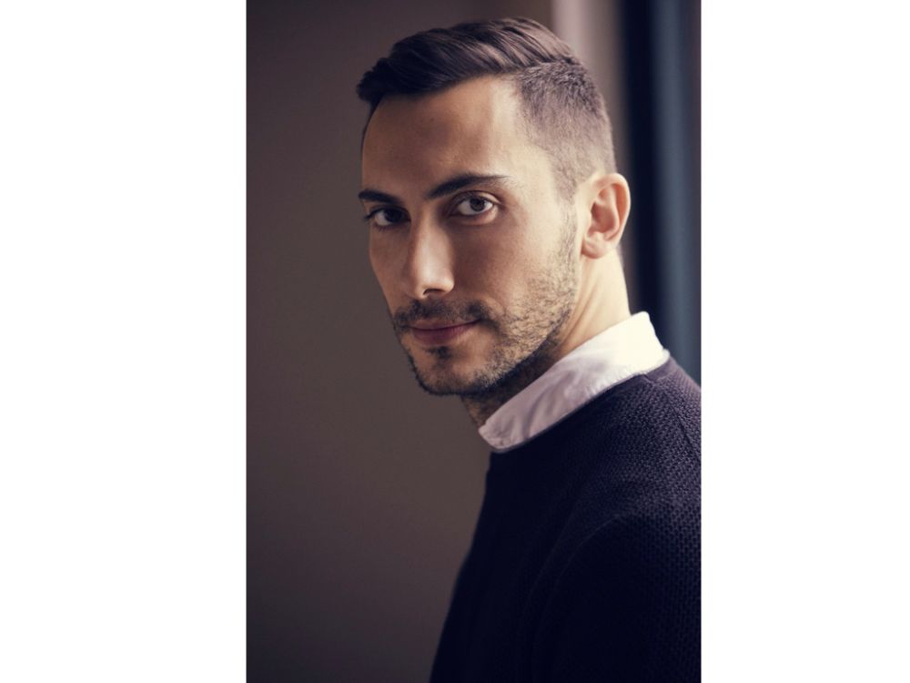 Headshot of Julian in collared shirt and dark sweater