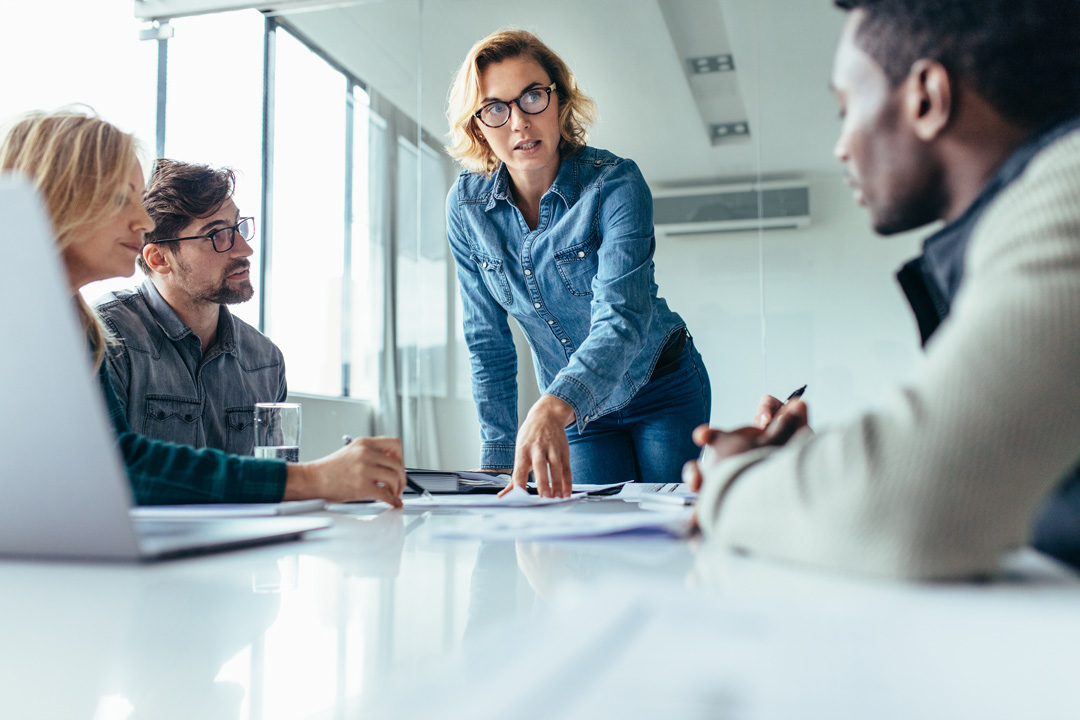 professional woman pointing to paper on a conference room table