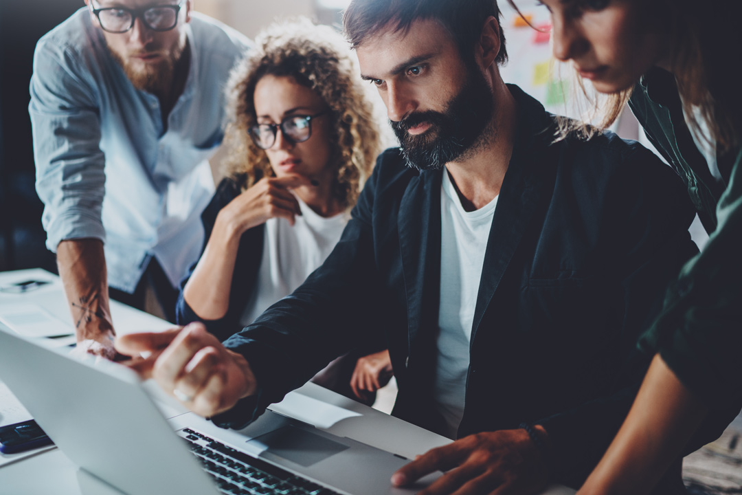 professionals crowded around a computer discussing a possible data breach