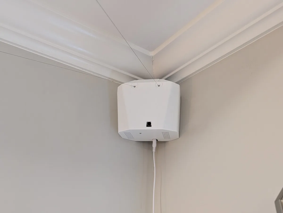 A Stringman anchor hung in the corner of a room below the crown moulding, with lines attached