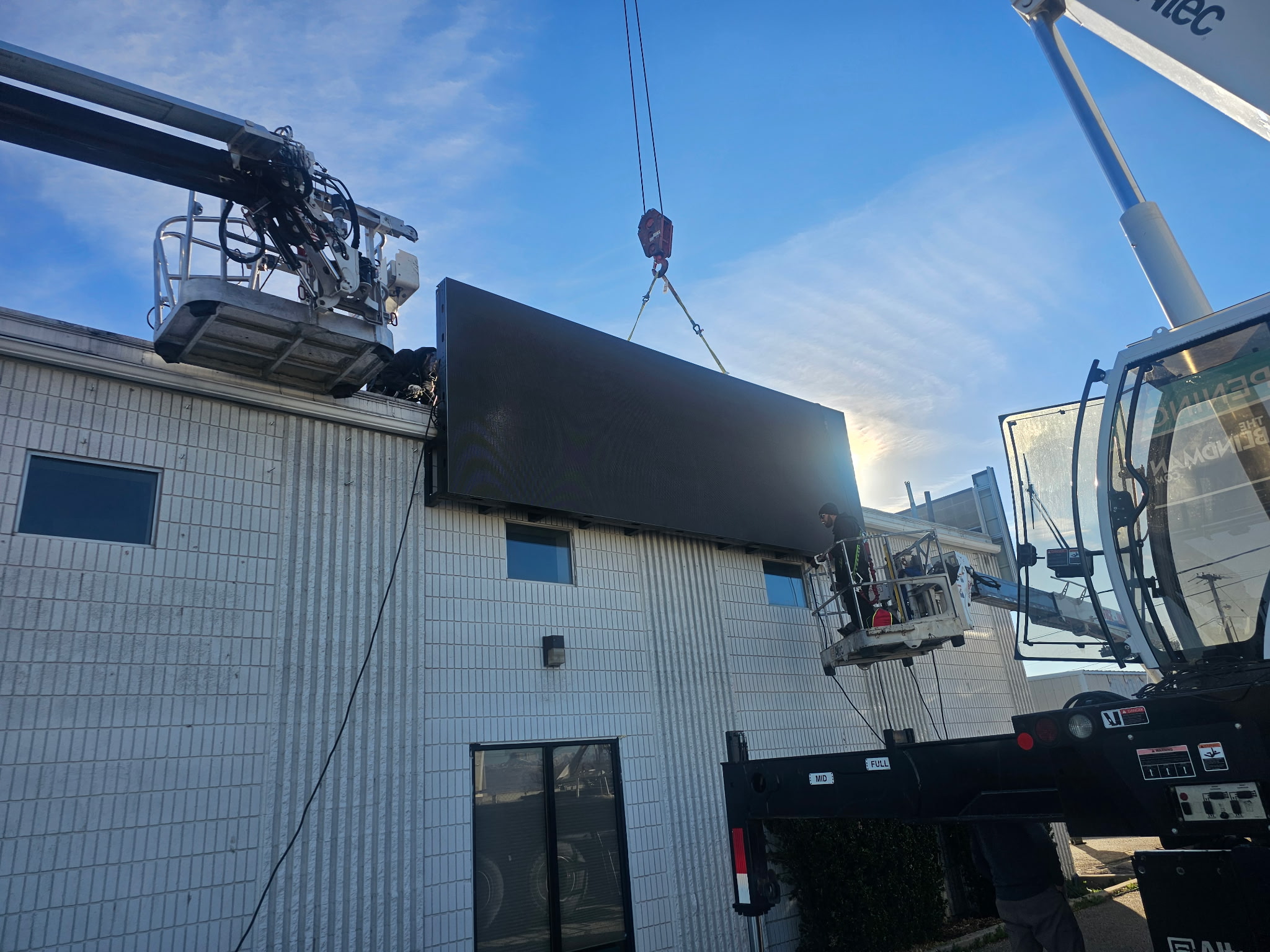 Technicians installing 7x20 foot commercial digital display frame.