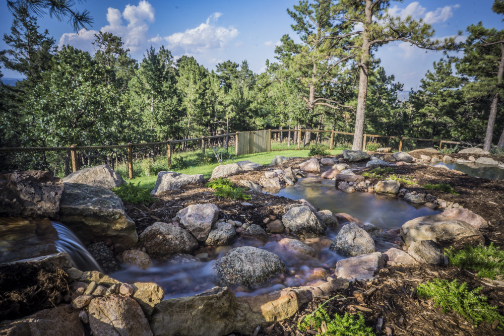 Hillside Outdoor Living with Natural Water Feature