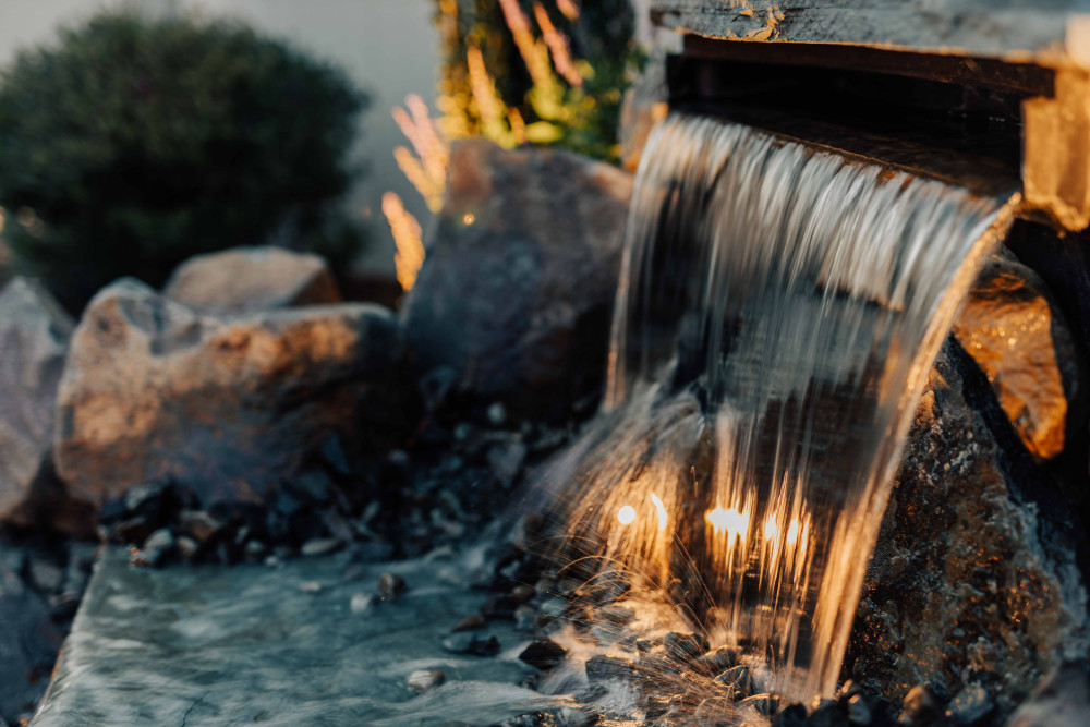 water feature with lights built in to create an elegant corner in this landscape