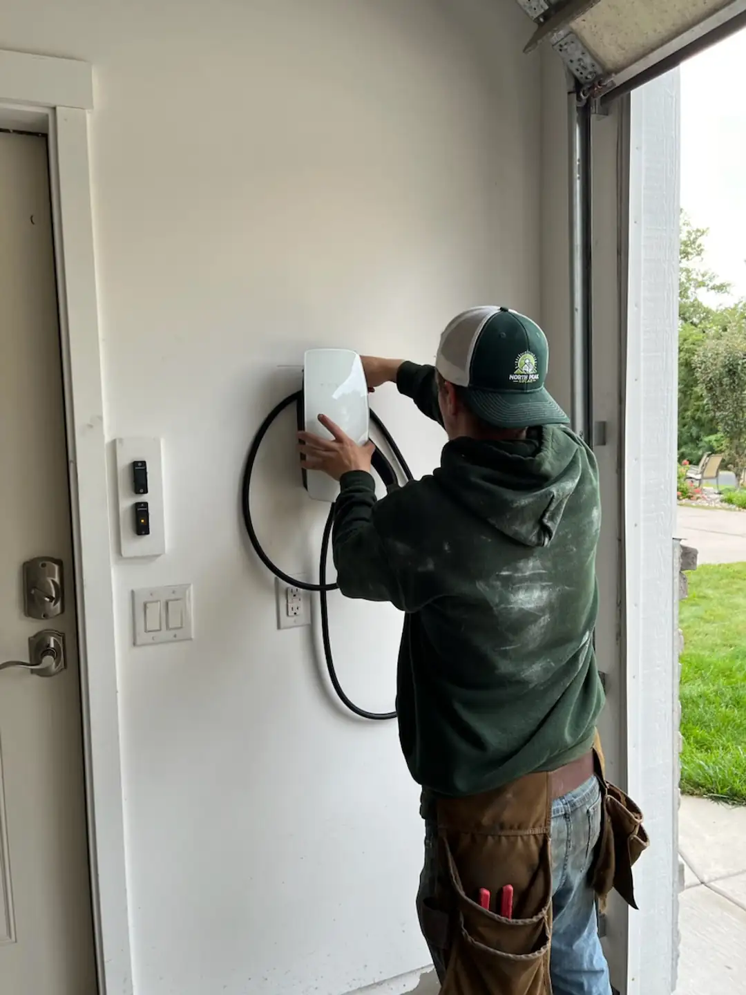 Homeowner plugging into a Level 2 EV charger