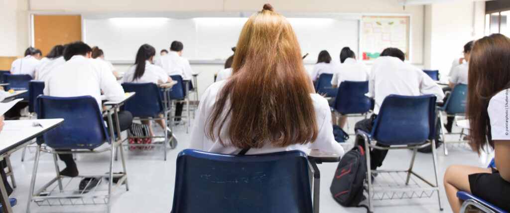 Treineiros do Enem sentados em uma sala de aula, imersos na realização do exame