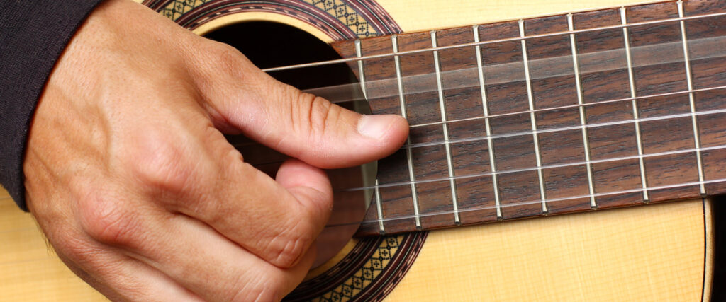 Corda do violão produzindo música.