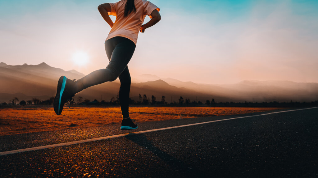 imagem mostra uma mulher correndo em um caminho livre com roupa de corrida. imagem mostra que se exercitar faz bem para a sua rotina de estudos.