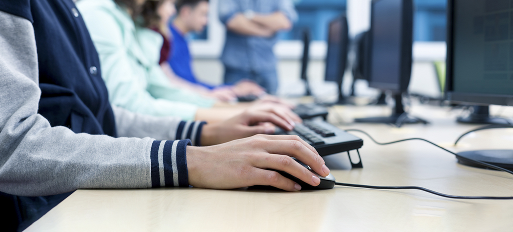 Foto de alunos estudando para o Enem de maneira digital usando um computador.