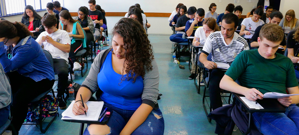 Alunos em sala de aula sentados em carteiras fazendo a prova do Enem para uso no processo Enem-Usp