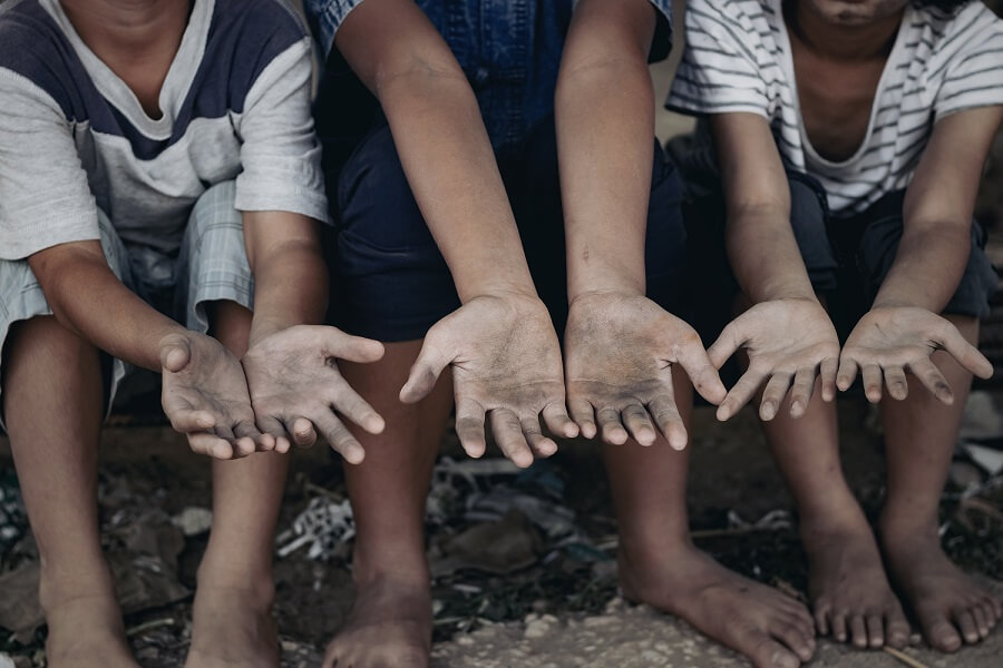 crianças mostram as mãos sujas simbolizando escravidão moderna