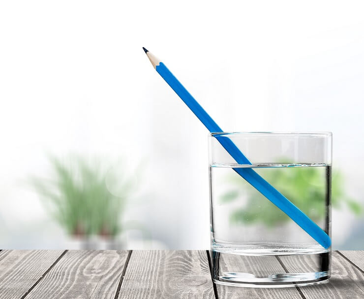 A aparente quebra no lápis ocorre pela mudança de direção da luz devido à sua refração (Imagem: Adobe Stock)