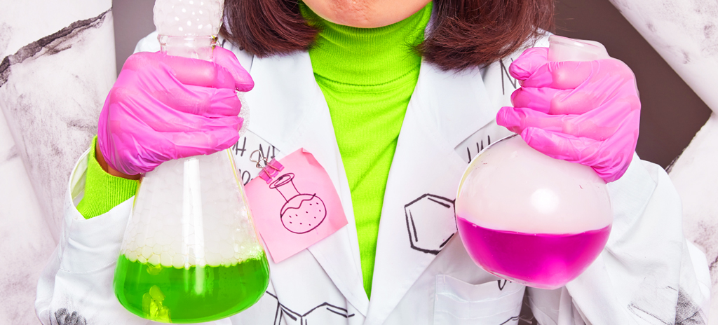 Mulher segurando vidros com soluções químicas