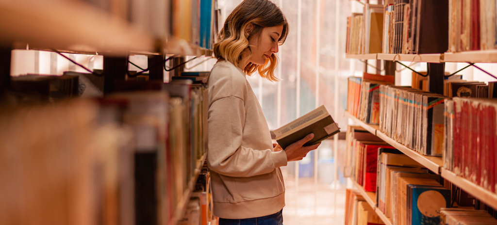 Estudante com livros na biblioteca