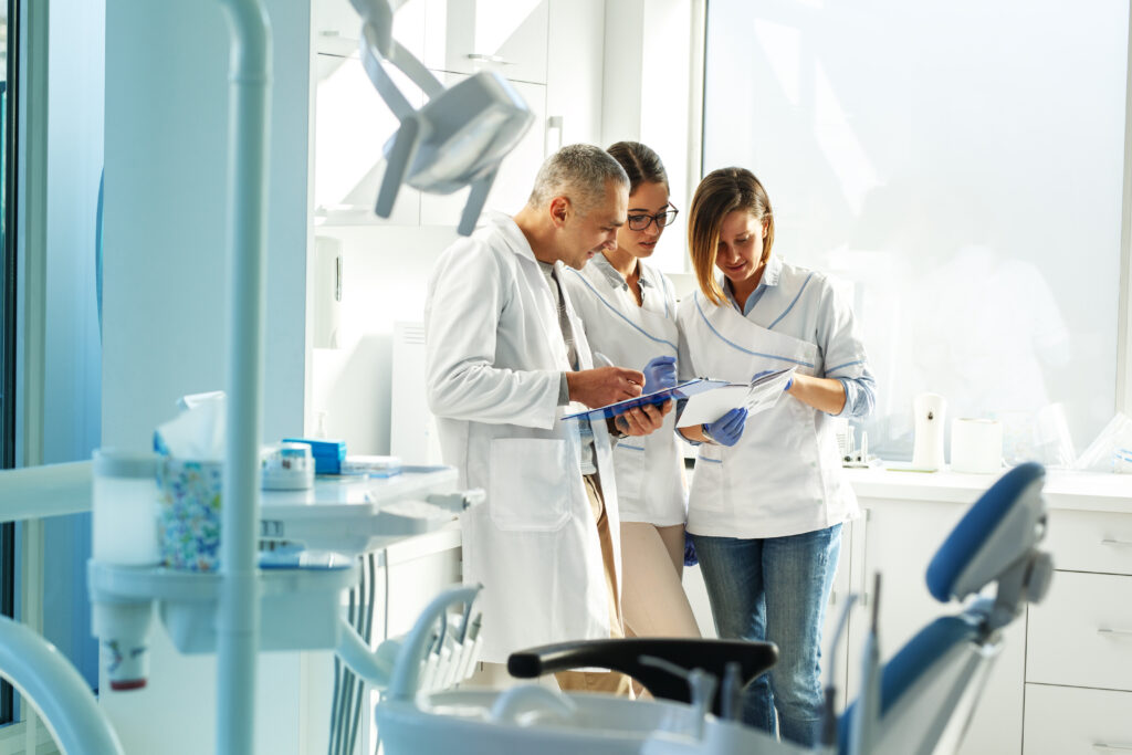 Equipe de dentista no consultório odontológico discutindo sobre os exames dos pacientes