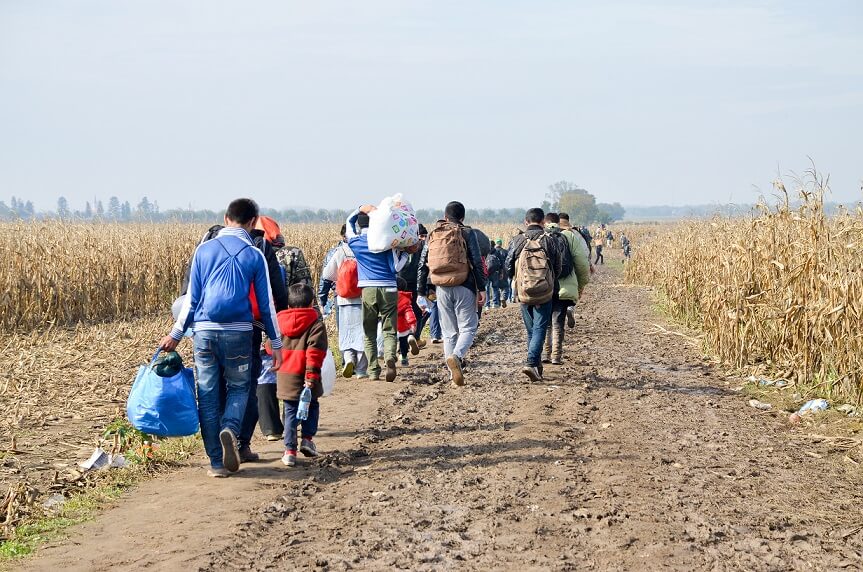 pessoas em estrada simbolizando fluxos migratórios